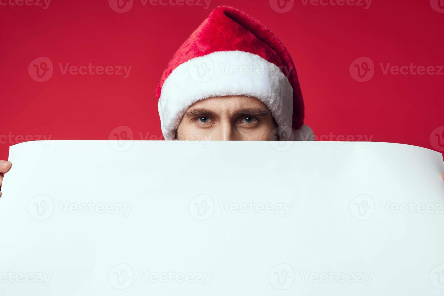 Cheerful man in a santa hat holding a banner holiday isolated background photo