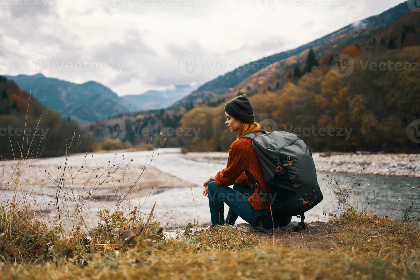 woman with backpack by the river mountain landscape autumn dry grass model photo