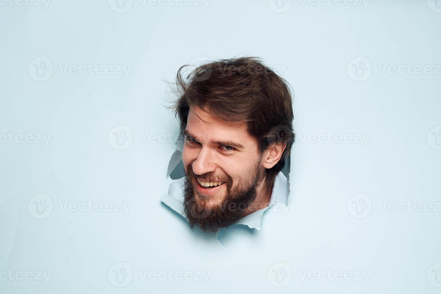 A bearded man peeps out from behind the wall dissatisfaction emotions office official photo