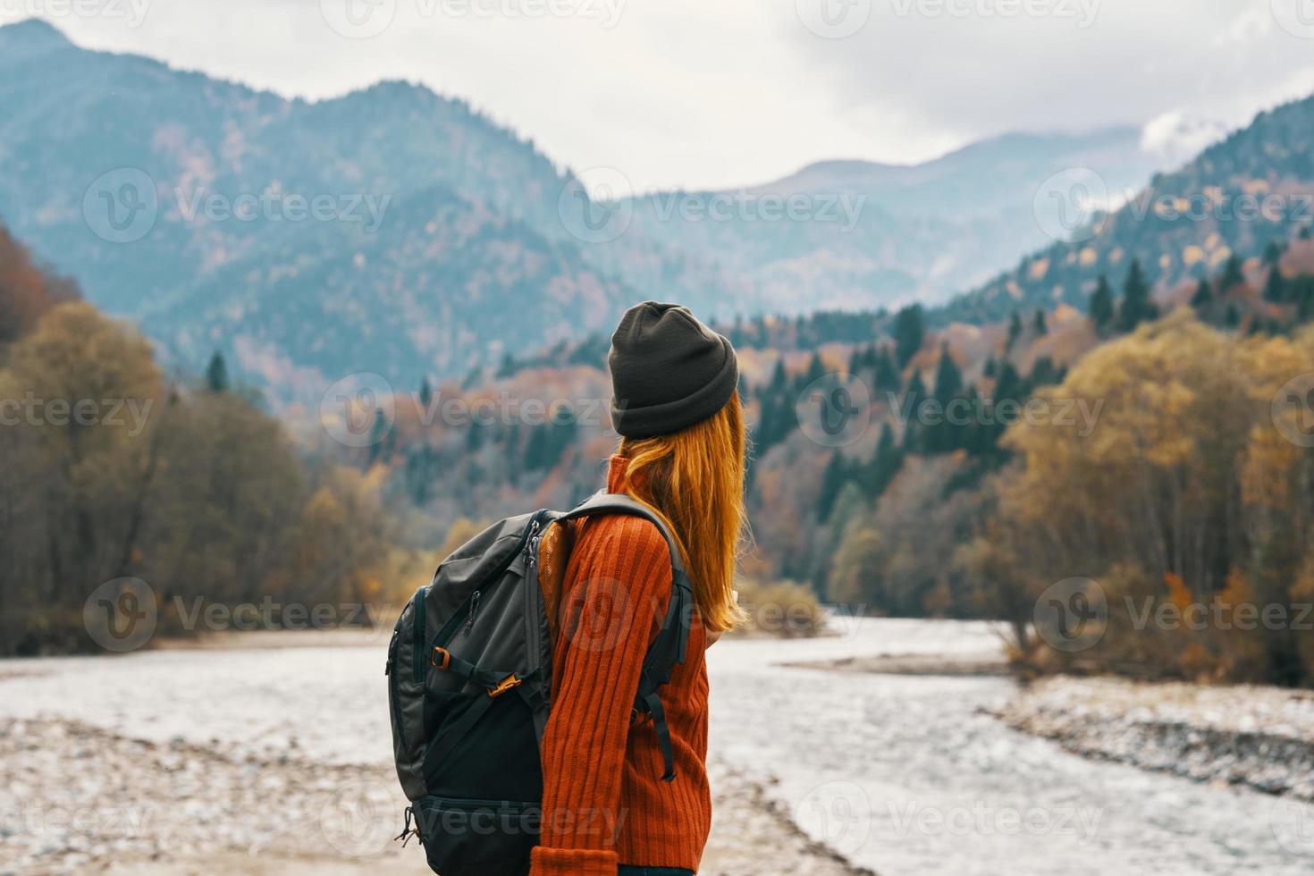 woman hiker with a backpack rest in the mountains in nature near the river photo