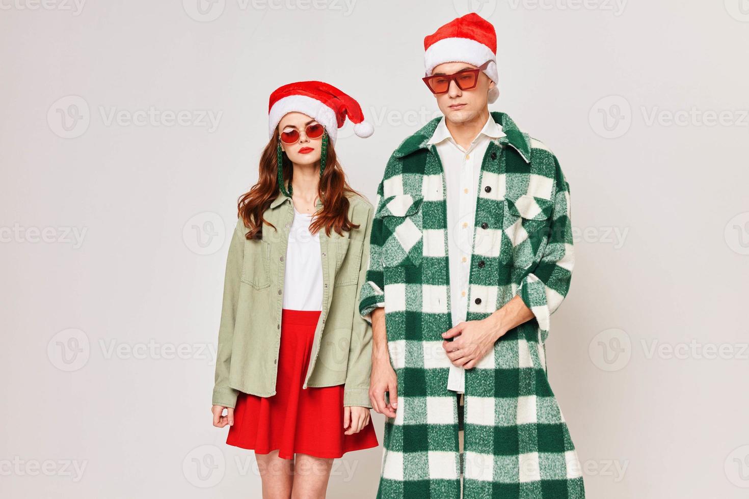 young couple are standing next to each other in christmas hats sunglasses fashion fun holiday photo