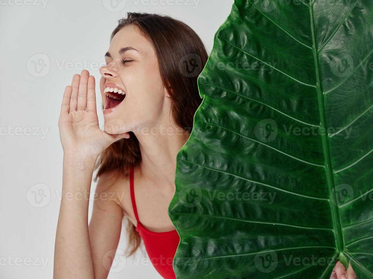 alegre mujer gritando en rojo traje de baño palma hoja emociones foto