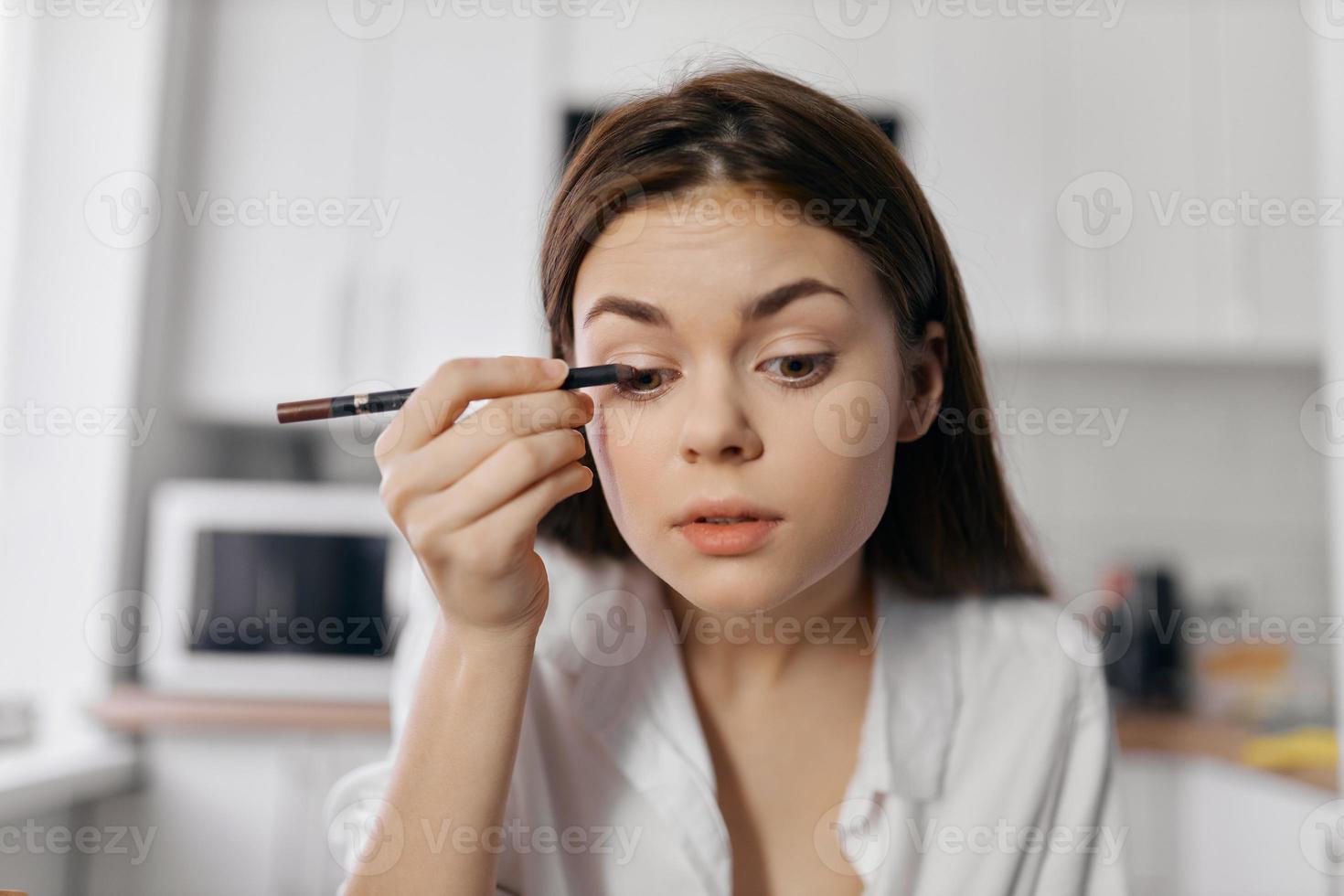 beautiful woman with eyeliner pencil makeup cosmetology room photo