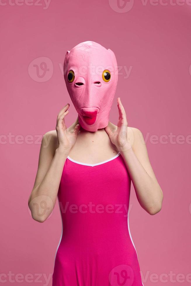 Very strange woman in a pink silicone fish mask for Halloween, crazy image in pink clothes photo
