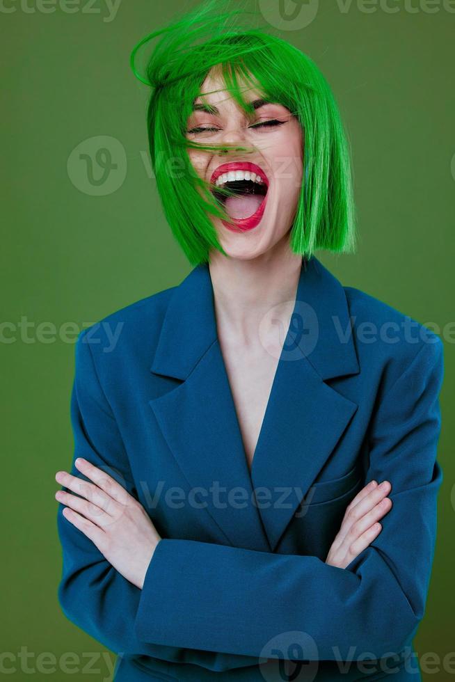 retrato de un encantador dama vistiendo un verde peluca azul chaqueta posando verde antecedentes inalterado foto