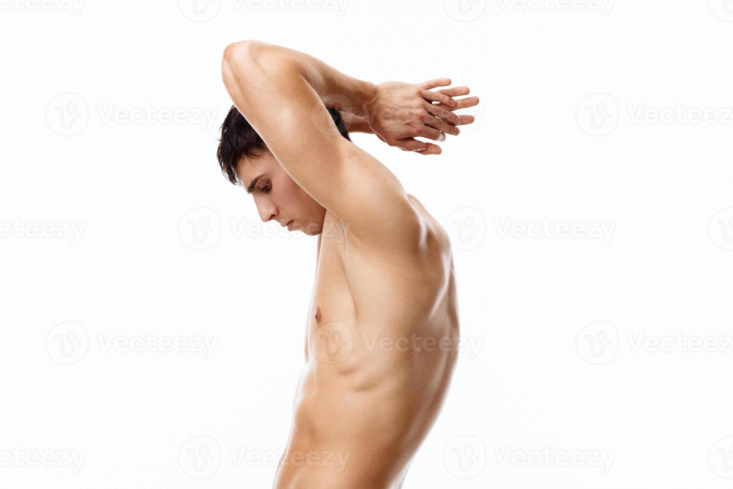 sports man with naked torso holds his hand behind his head and muscles bodybuilder model photo