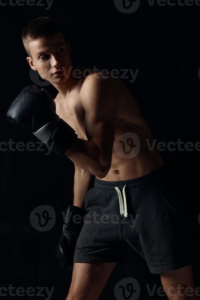 Boxer inclinado adelante en negro antecedentes con guantes recortado ver foto