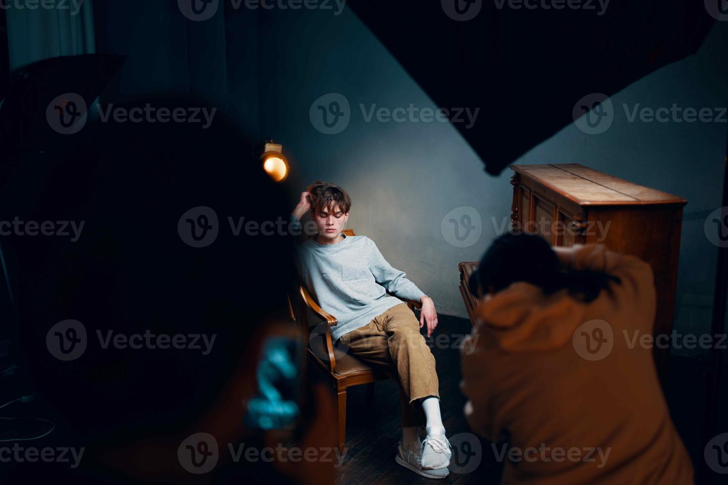 guy sitting on a chair next to the piano posing photo