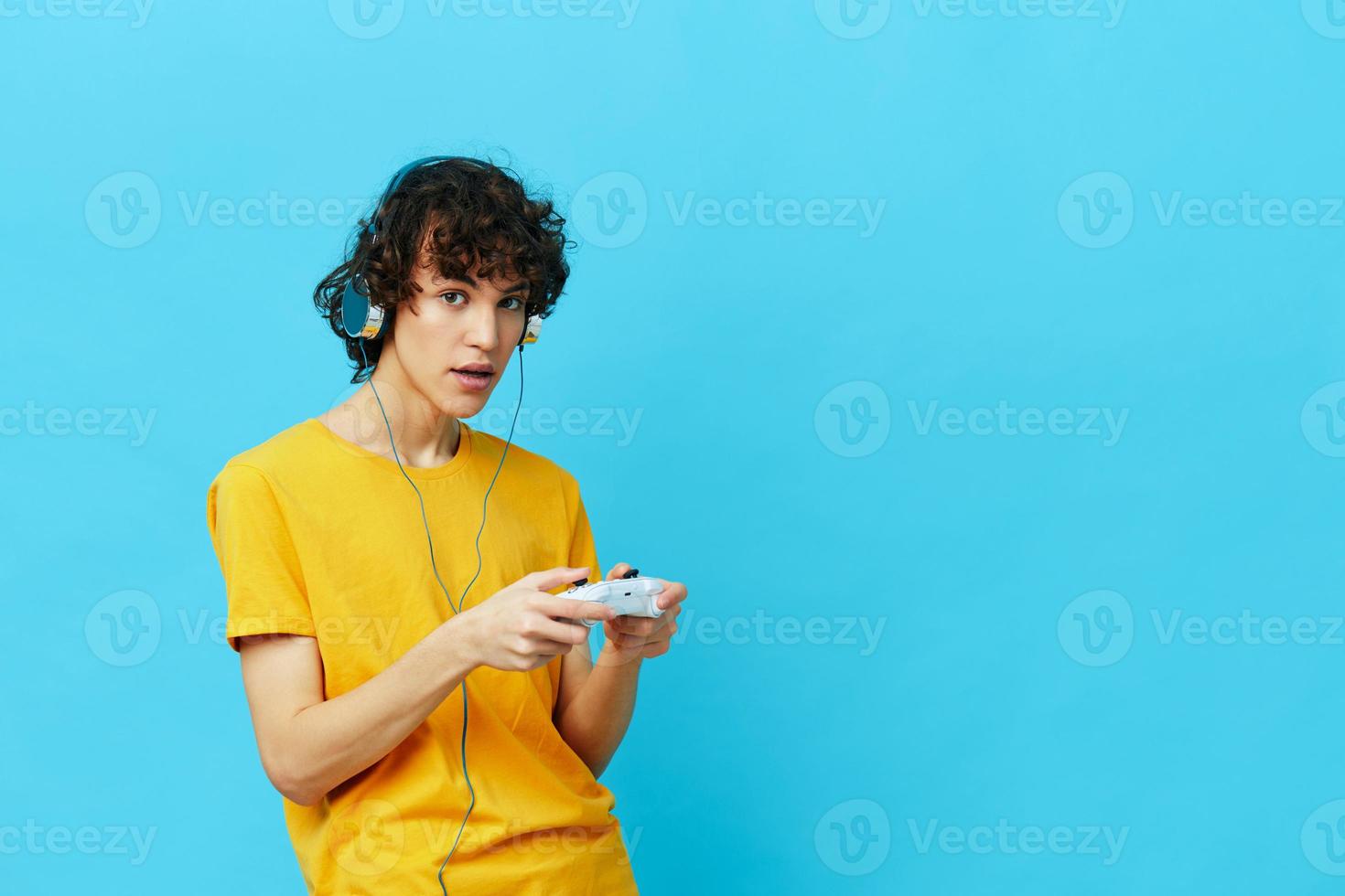 curly guy yellow T-shirt with joystick video games isolated backgrounds photo