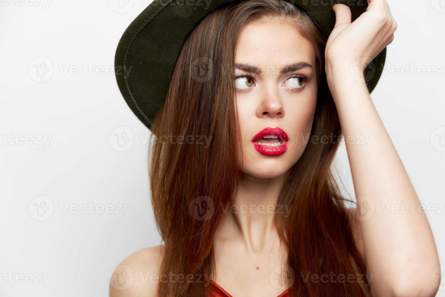 Woman in a hat looking to the side hand near the face photo