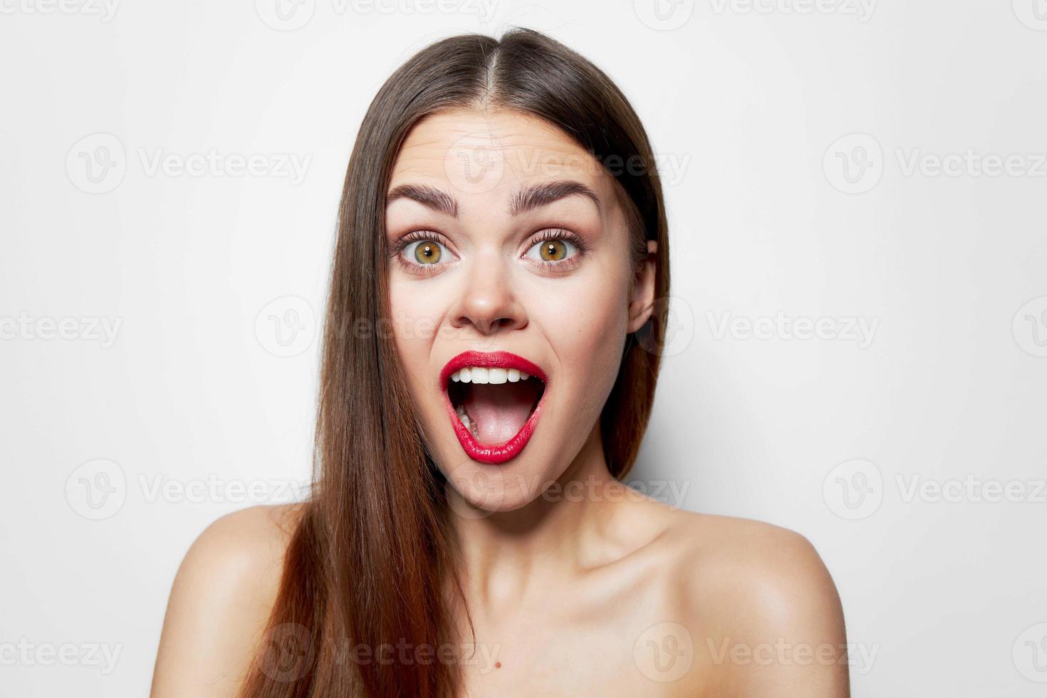 emotional woman wide open mouth highlighting bare shoulders studio photo