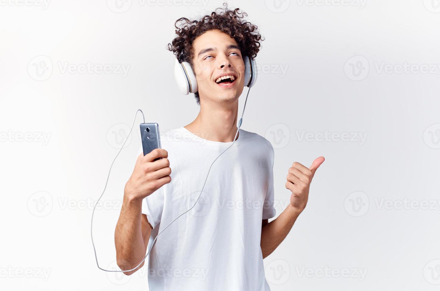 funny curly guy in headphones listens to music emotions entertainment photo
