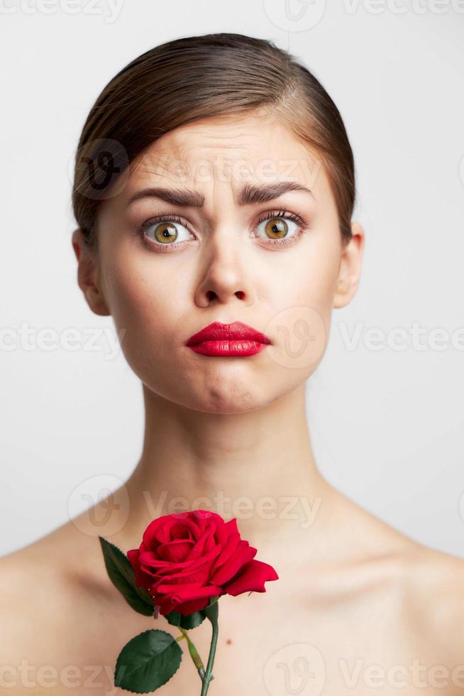 Brunette with bare Roses in the hands of a sad expression shoulders photo