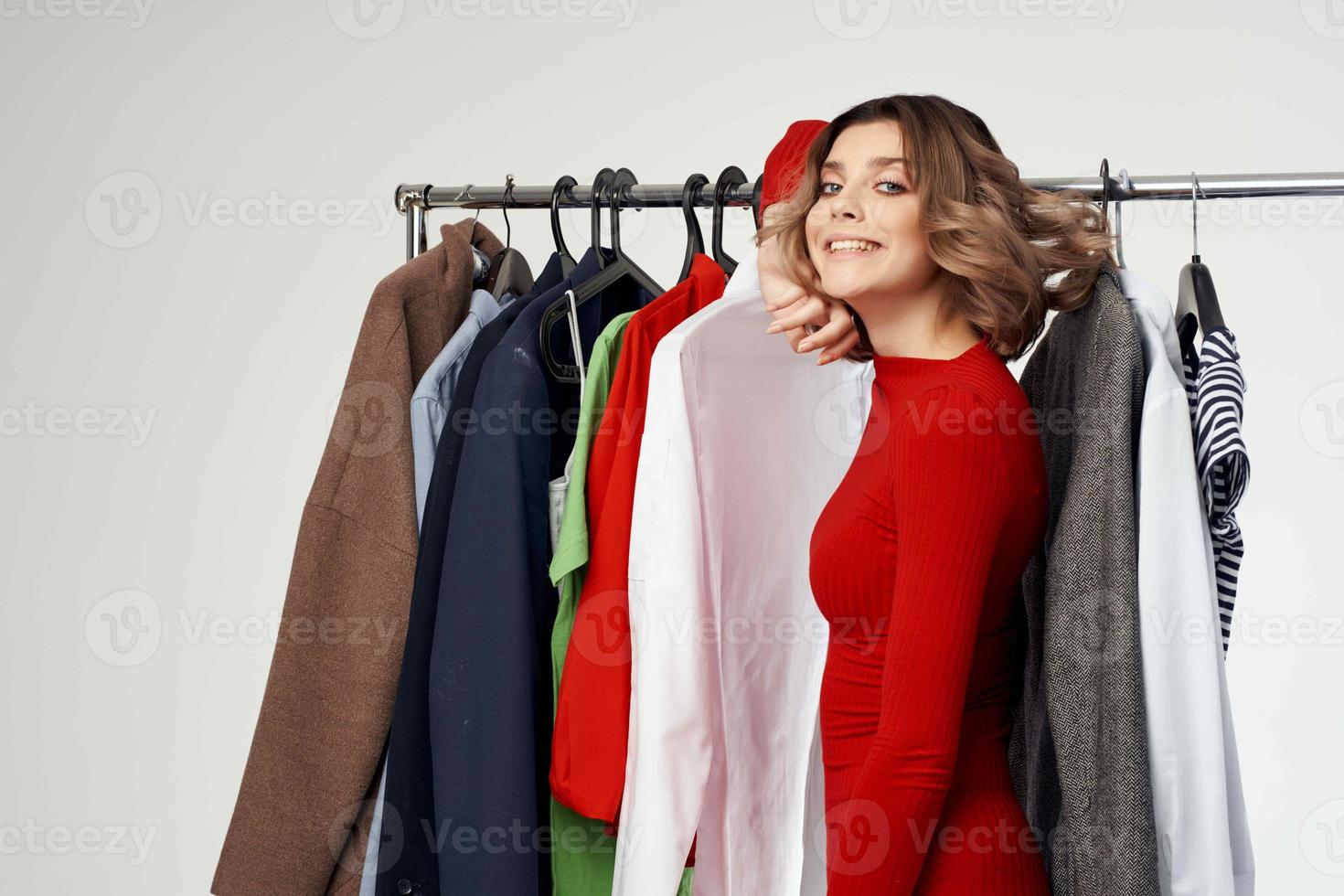 pretty woman in a red jacket near the wardrobe light background photo