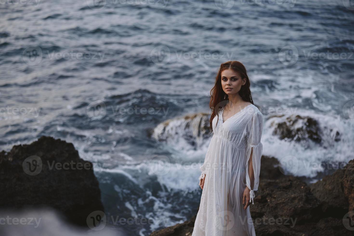 attractive woman in white dress posing by the ocean nature unaltered photo