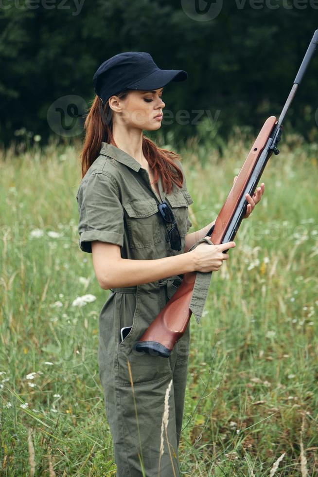 mujer mira a el pistola caza estilo de vida verde mono negro gorra foto