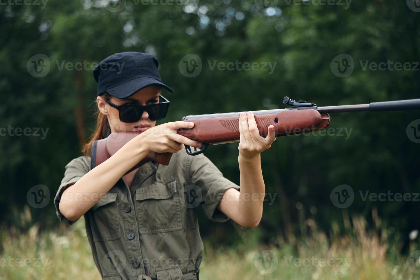 Military woman hunting with shotgun sunglasses green leaves photo