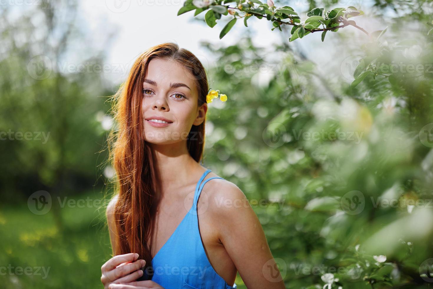retrato de un niña en primavera y verano cerca un verde árbol en el parque sonriente en un azul vestir sensibilidad y belleza foto