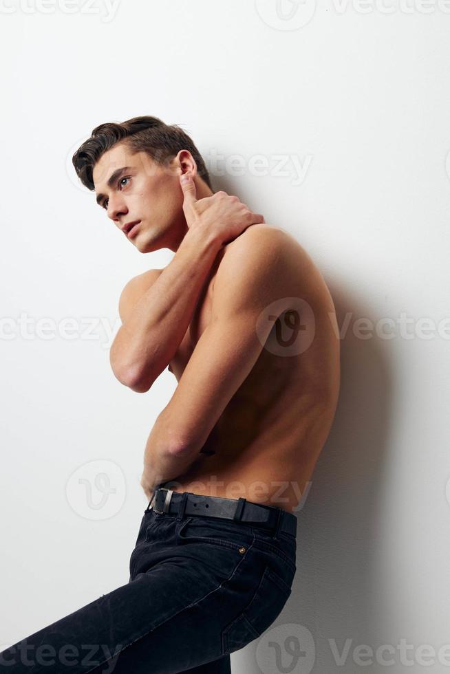 guy with a naked torso holds his hand behind his head pants model photo