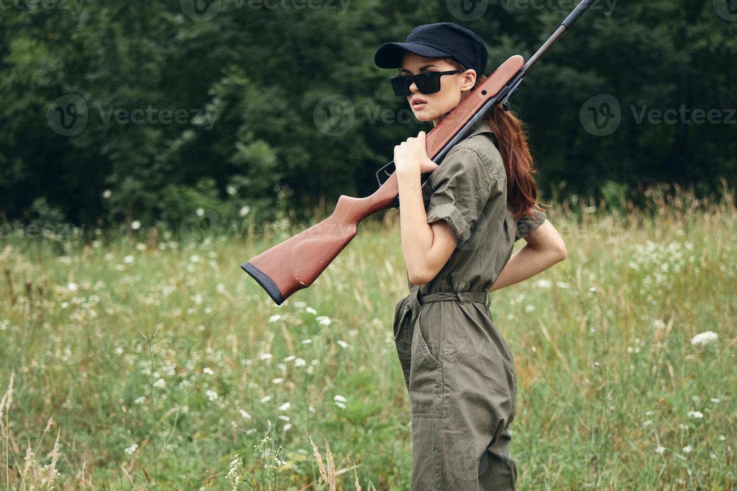 Woman weapon in hands jumpsuit hunting weapons green photo