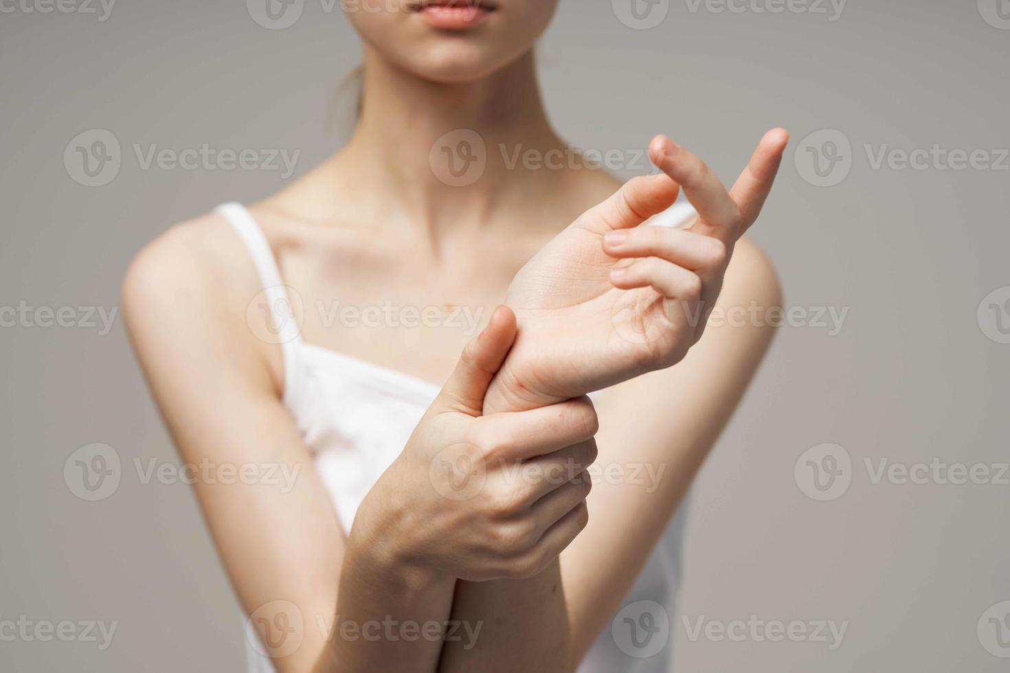 woman in white t-shirt holding on to the arm health problems joint studio treatment photo