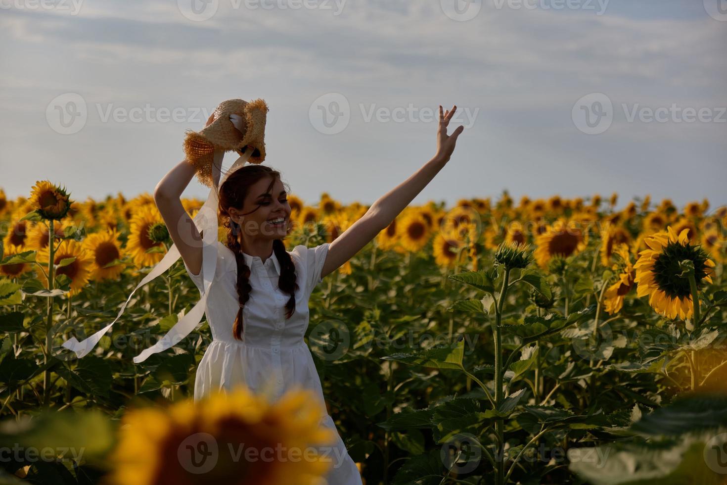 woman with two pigtails In a field with blooming sunflowers unaltered photo