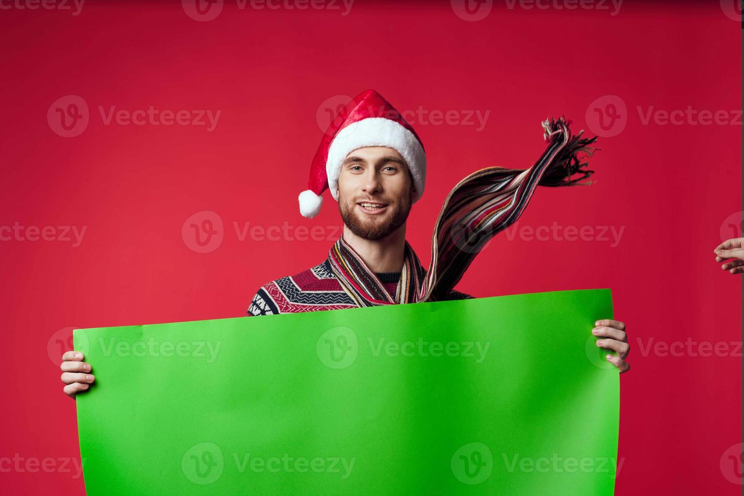 handsome man in a christmas hat with green mockup studio posing photo