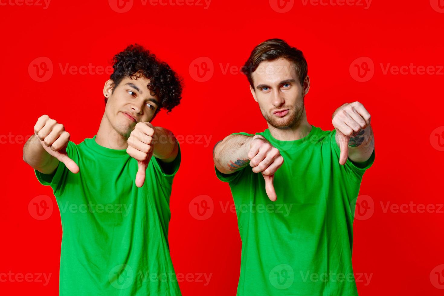 Happy Friends in Green T-shirts Show Thumbs Down Emotions photo
