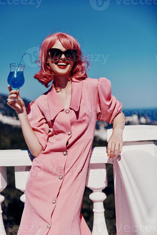 attractive woman enjoying a colorful cocktail on the panoramic view hotel terrace Happy female relaxing photo