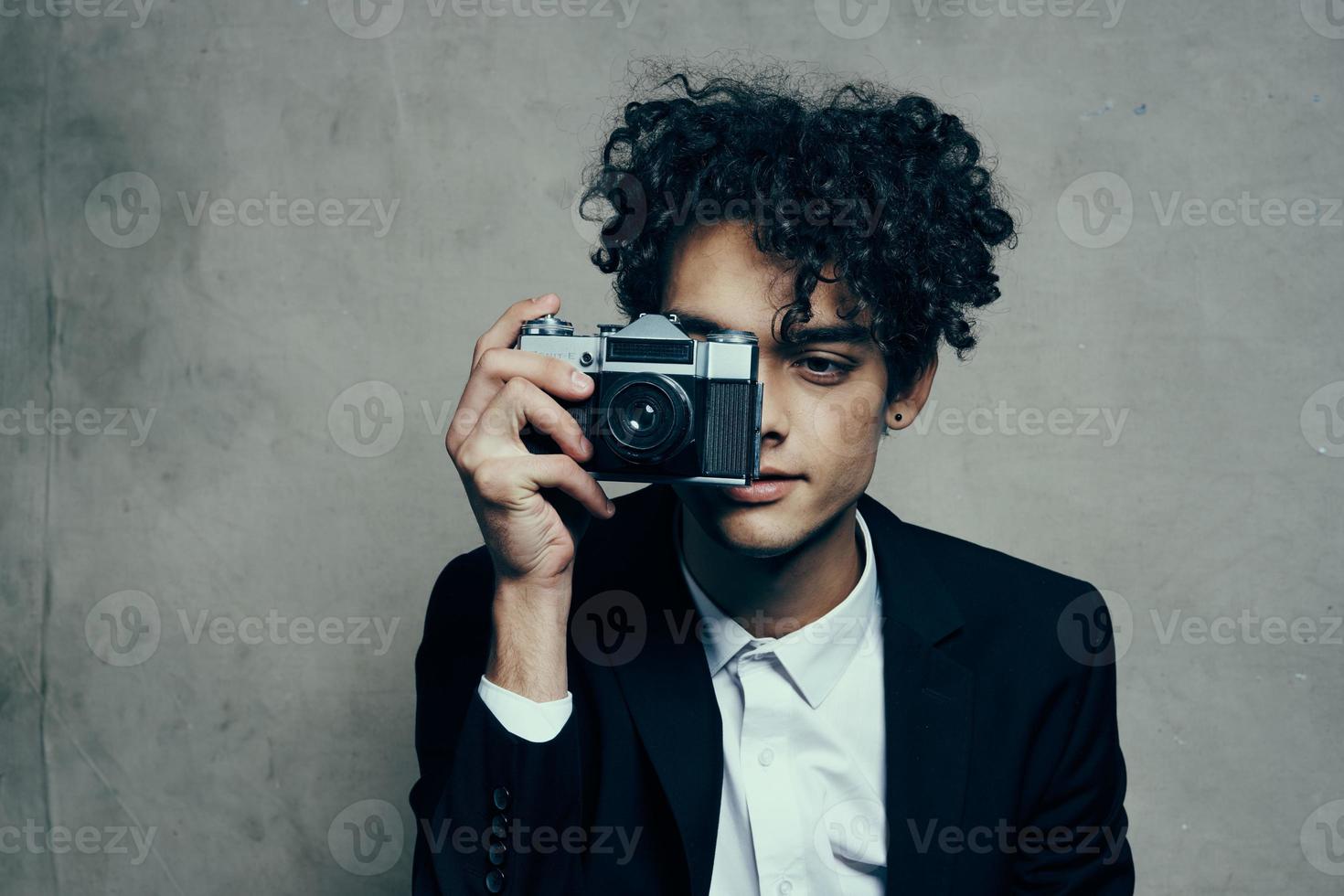 fotógrafo con un cámara en un clásico traje Rizado pelo estudio modelo foto