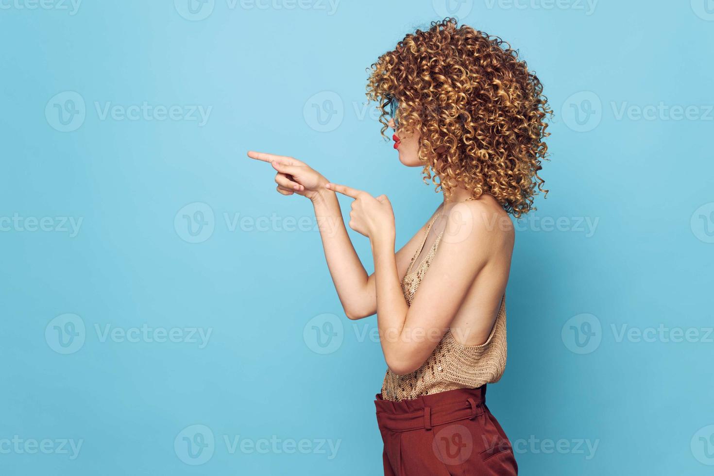 Woman portrait Curly hair side view gesture with fingers Copy Space brown pants photo