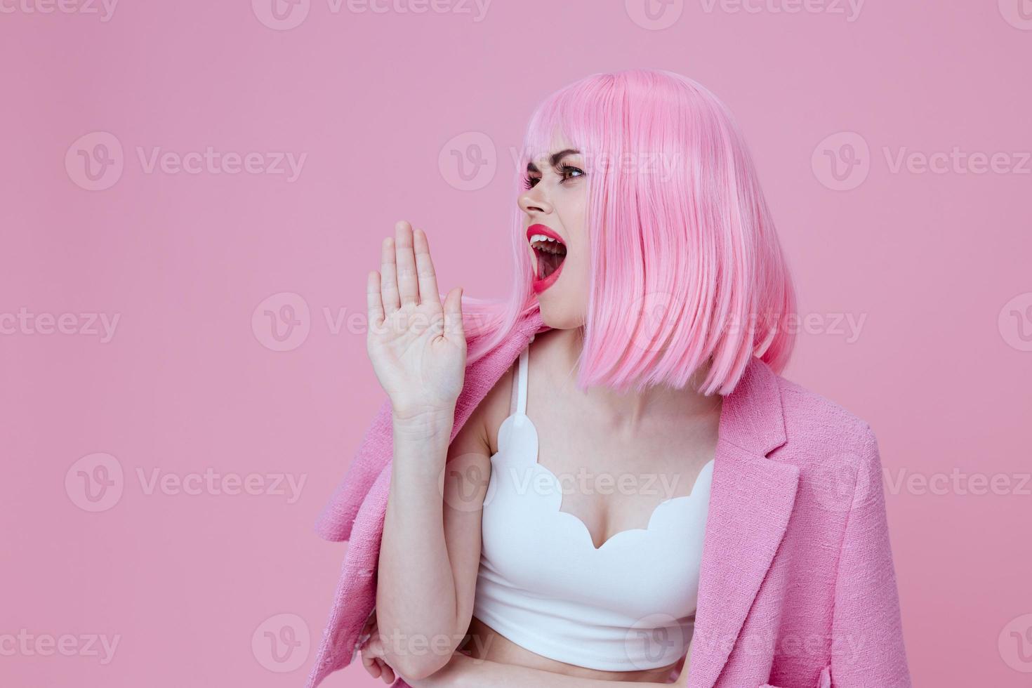 Beautiful fashionable girl gestures with his hands with a pink jacket color background unaltered photo