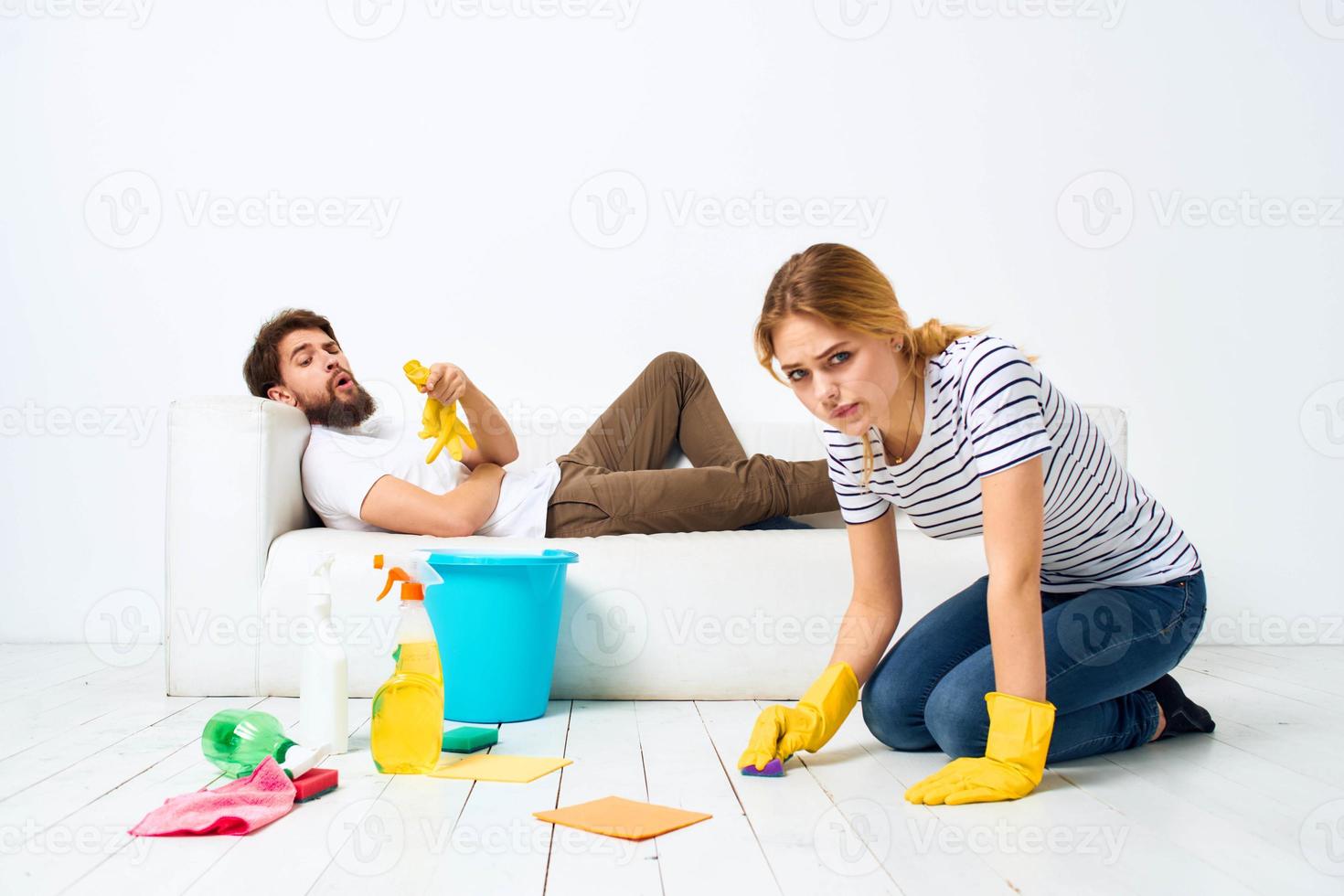 The man lies on the sofa woman washes the floors providing services interior housework photo