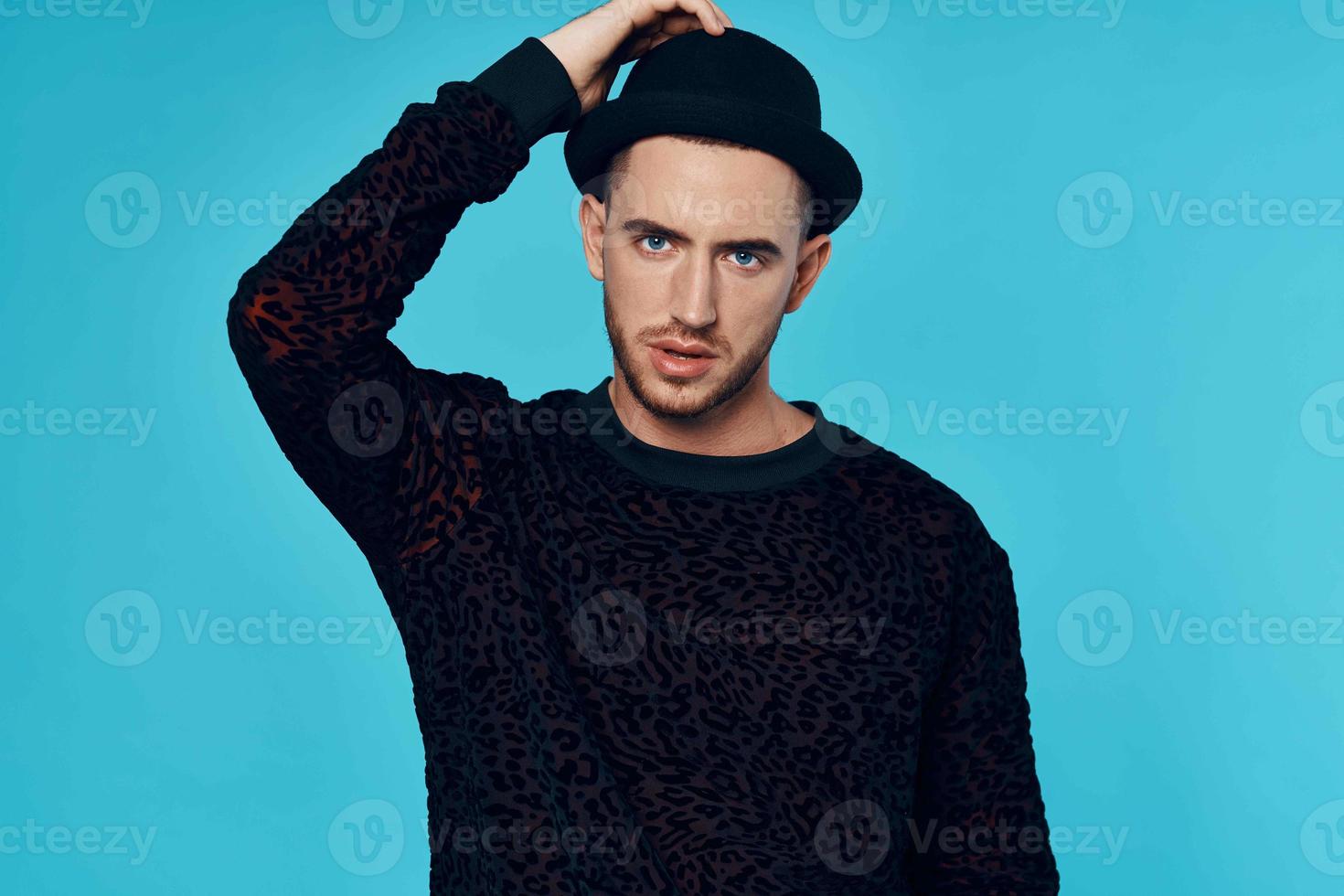 man in black sweater caps posing fashion studio blue background photo