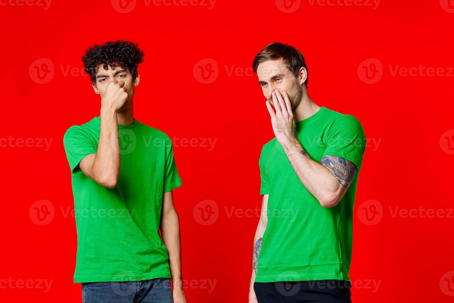 two friends cover their hand face emotions displeasure red background photo