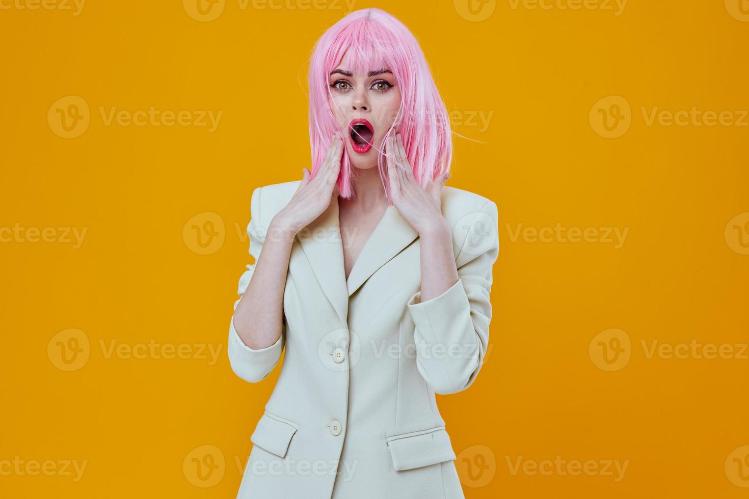 Woman in white suit pink wig posing on yellow background photo