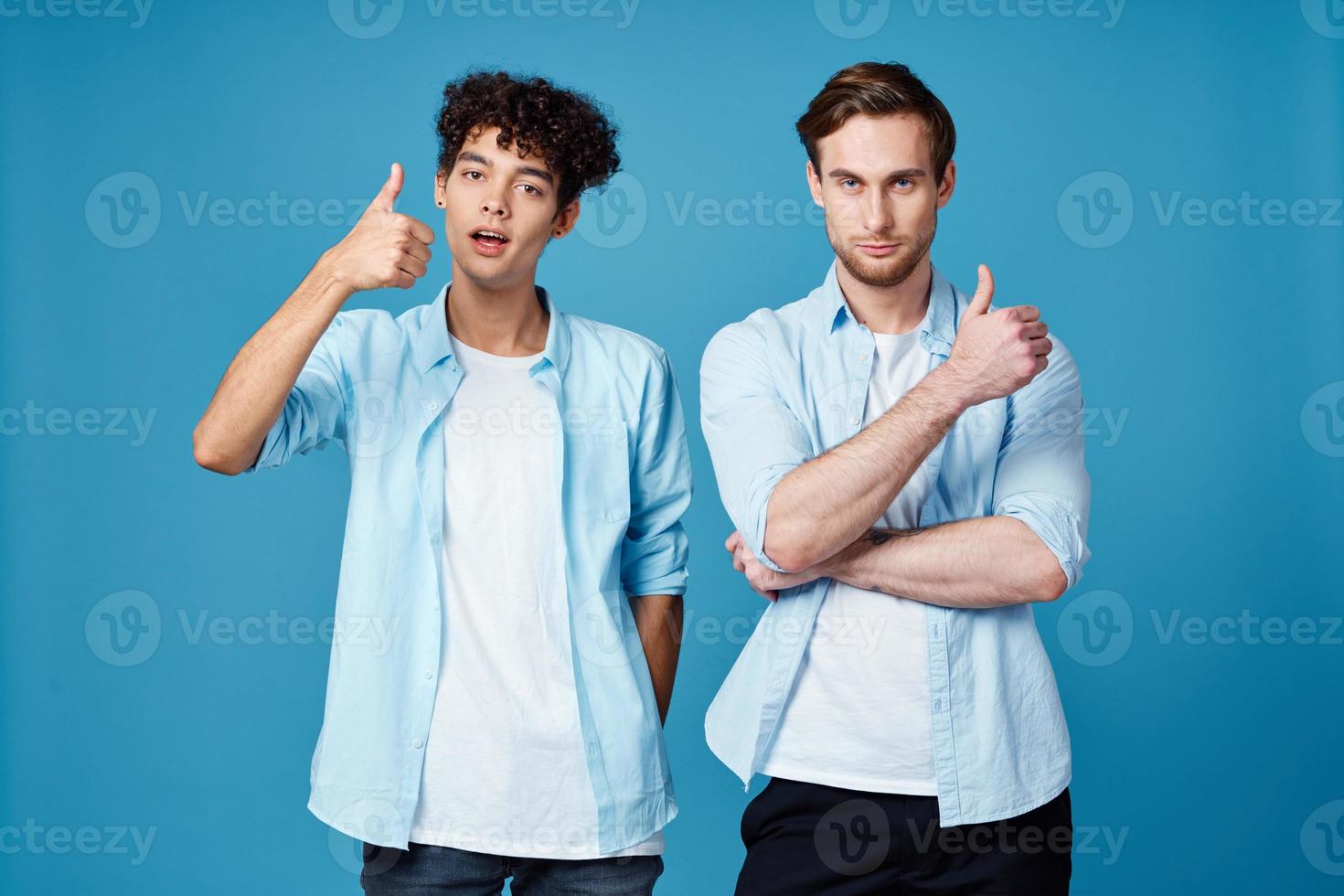 men in identical shirts and white t-shirts on a blue background chatting friends cropped view photo