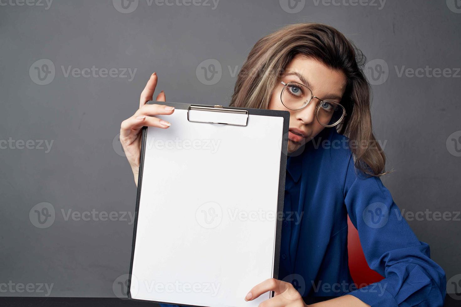 business woman with glasses sits at the table while holding Copy Space photo