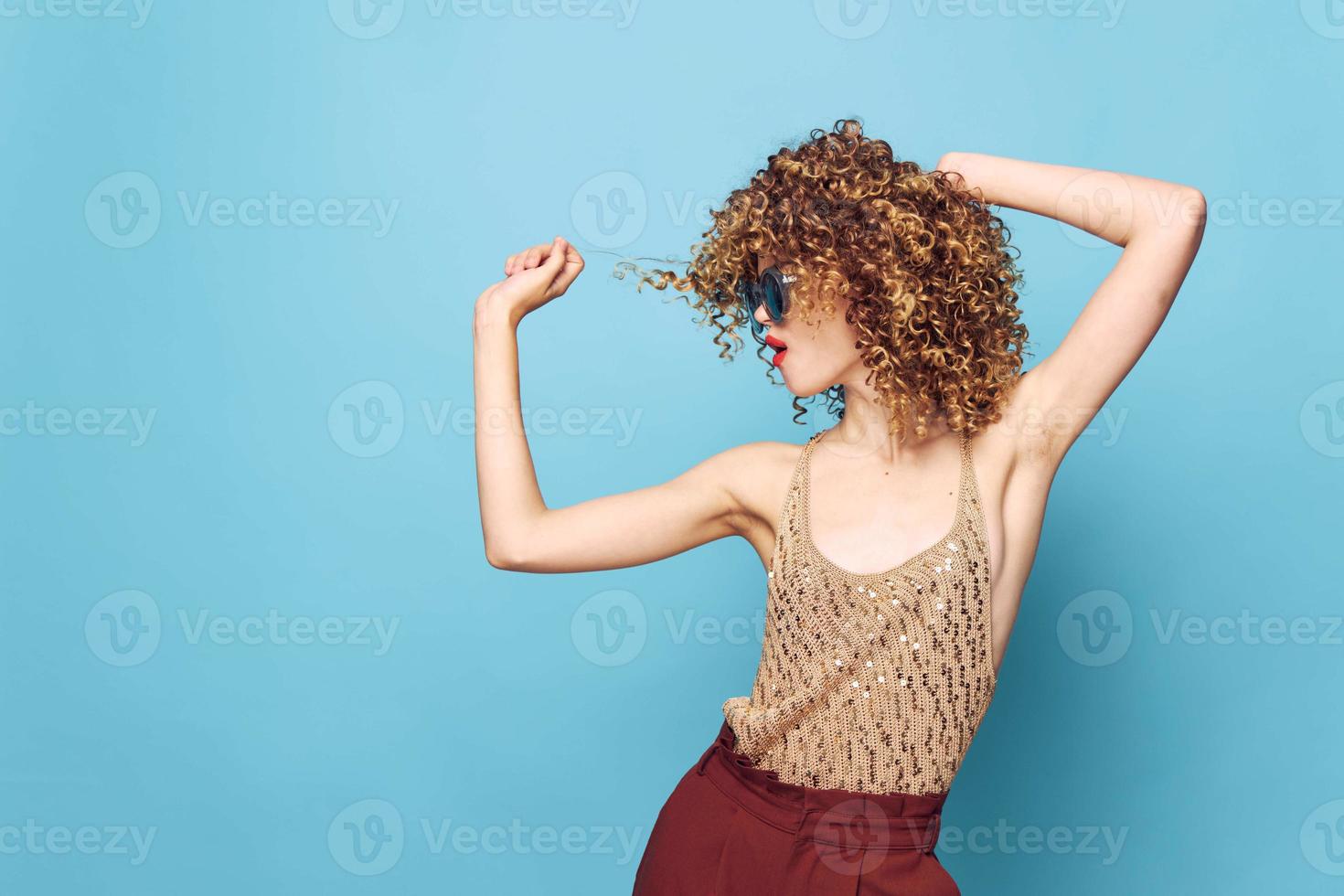 Sexy model Curly hair dark glasses attractive look blue background sequin shirt photo