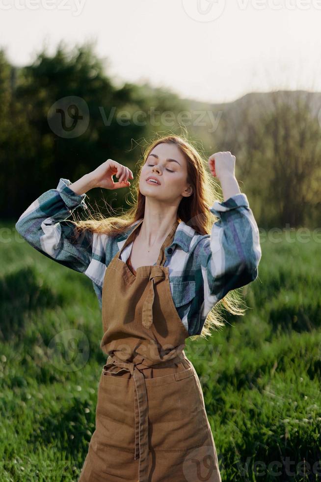 Portrait of a young girl on a summer day in the rays of the setting sun with a beautiful smile, dressed as a farmer and gardener photo