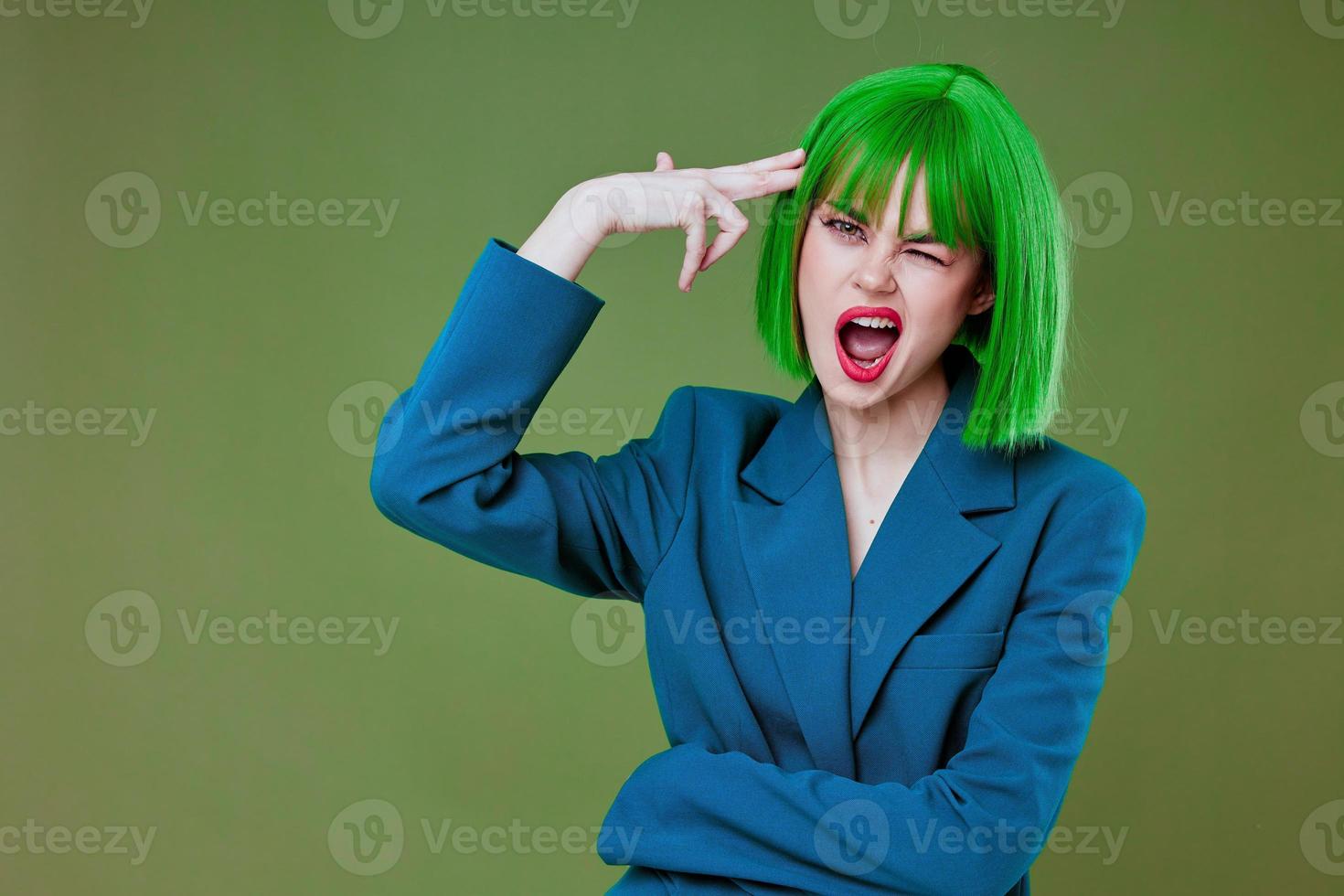 Positive young woman Glamor green wig red lips blue jacket green background unaltered photo