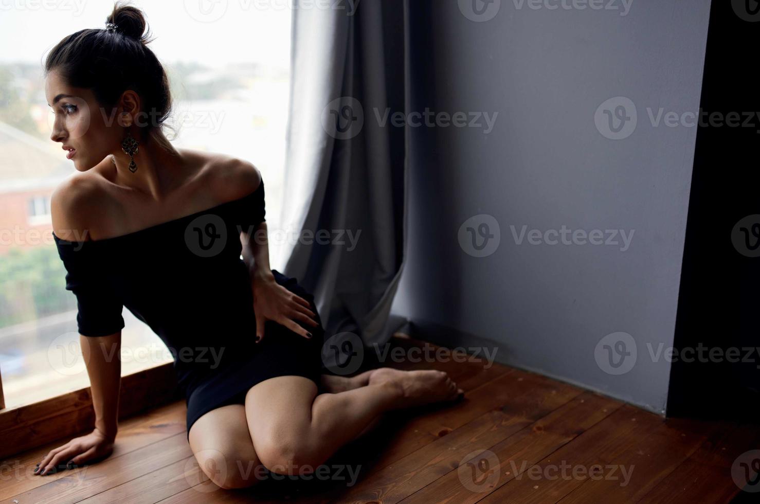 brunette in a black dress near the window posing fashion model photo