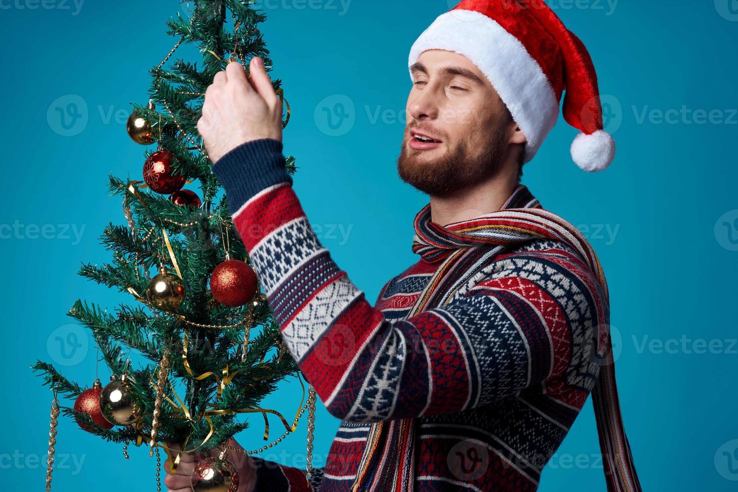 Cheerful man in a santa hat holding a banner holiday blue background photo