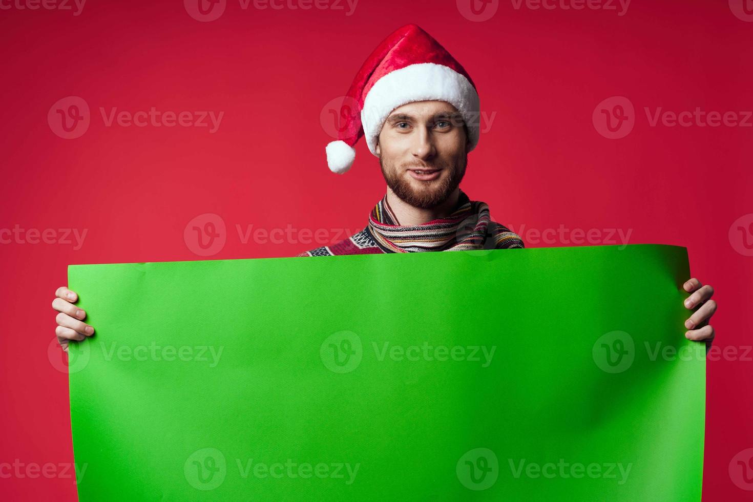 Cheerful man in a santa hat holding a banner holiday studio posing photo