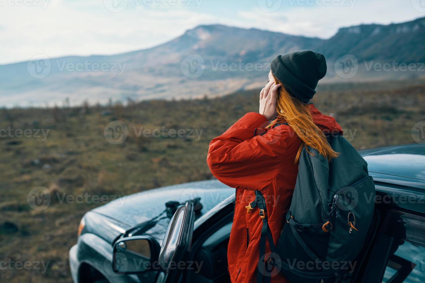 woman hiker in the mountains on nature near the car with a backpack on the back photo