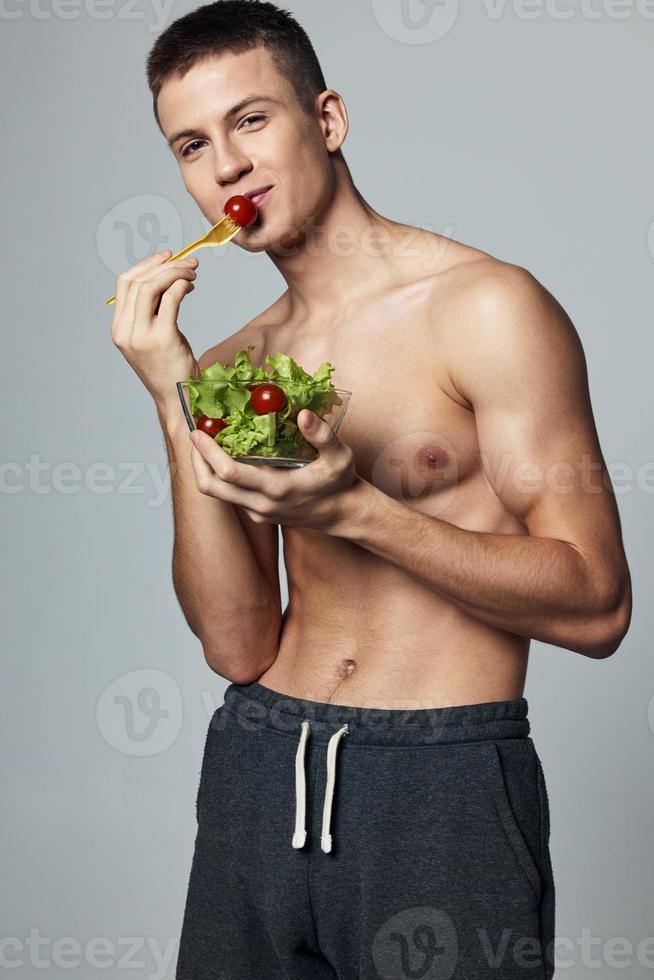 Deportes chico con un desnudo torso plato de vegetal ensalada aislado antecedentes foto