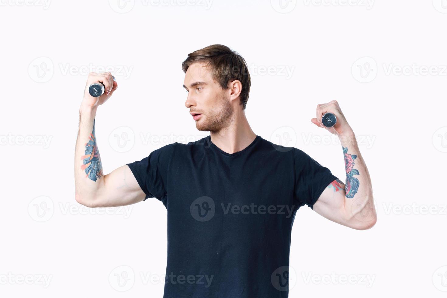 man with pumped up muscles of arms and dumbbells black t-shirt white background photo