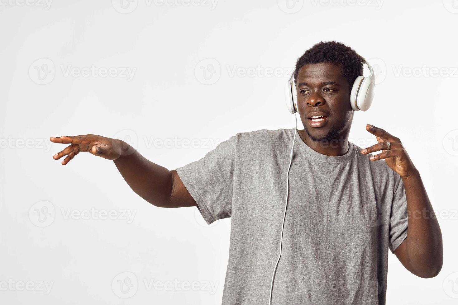 Cheerful man of African appearance in headphones listens to music photo