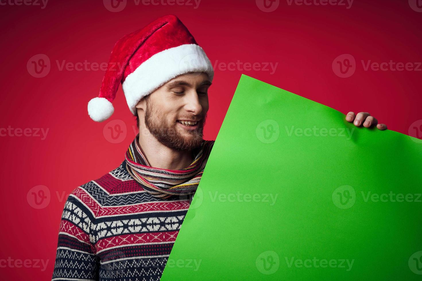 Cheerful man in a santa hat holding a banner holiday studio posing photo