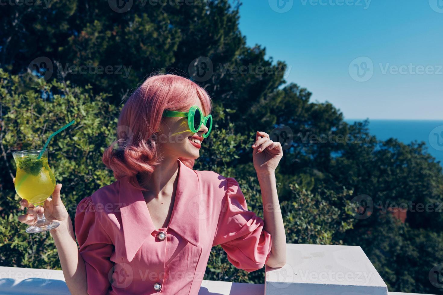 Delighted young girl in green sunglasses with cocktail in summer outdoors unaltered photo